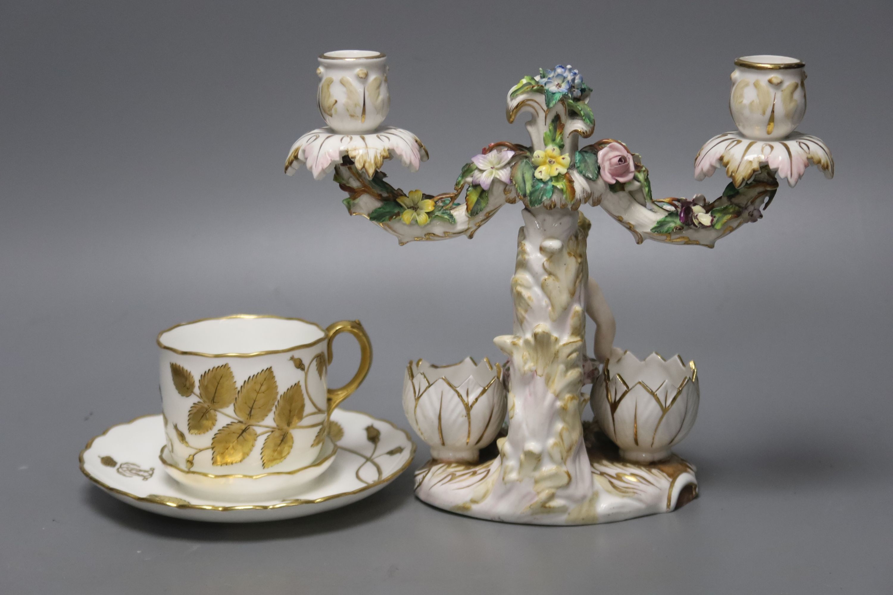 A John Bevington figural candelabra, height 19cm, and a cup and trembleuse saucer